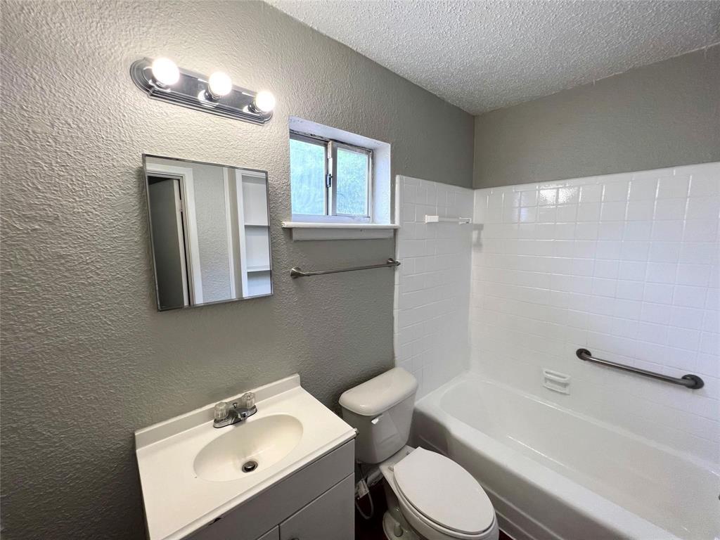 6363 Hollis Avenue Dallas, TX 75227 - Photo 4 of 6 a bathroom with a sink toilet and shower