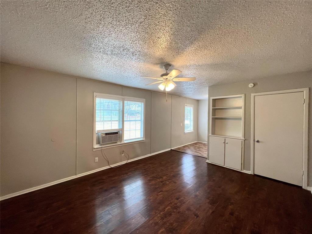 6363 Hollis Avenue Dallas, TX 75227 - Photo 6 of 6 an empty room with wooden floor chandelier and windows