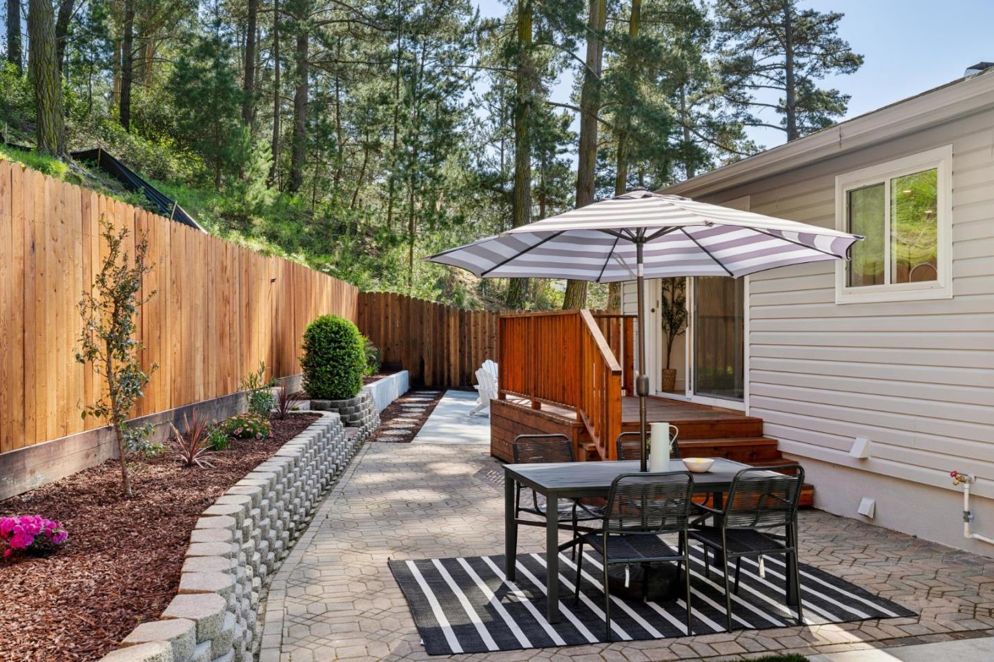 2 Celia Court Pacifica, CA 94044 - Photo 36 of 47 a view of a patio with table and chairs under an umbrella with wooden fence