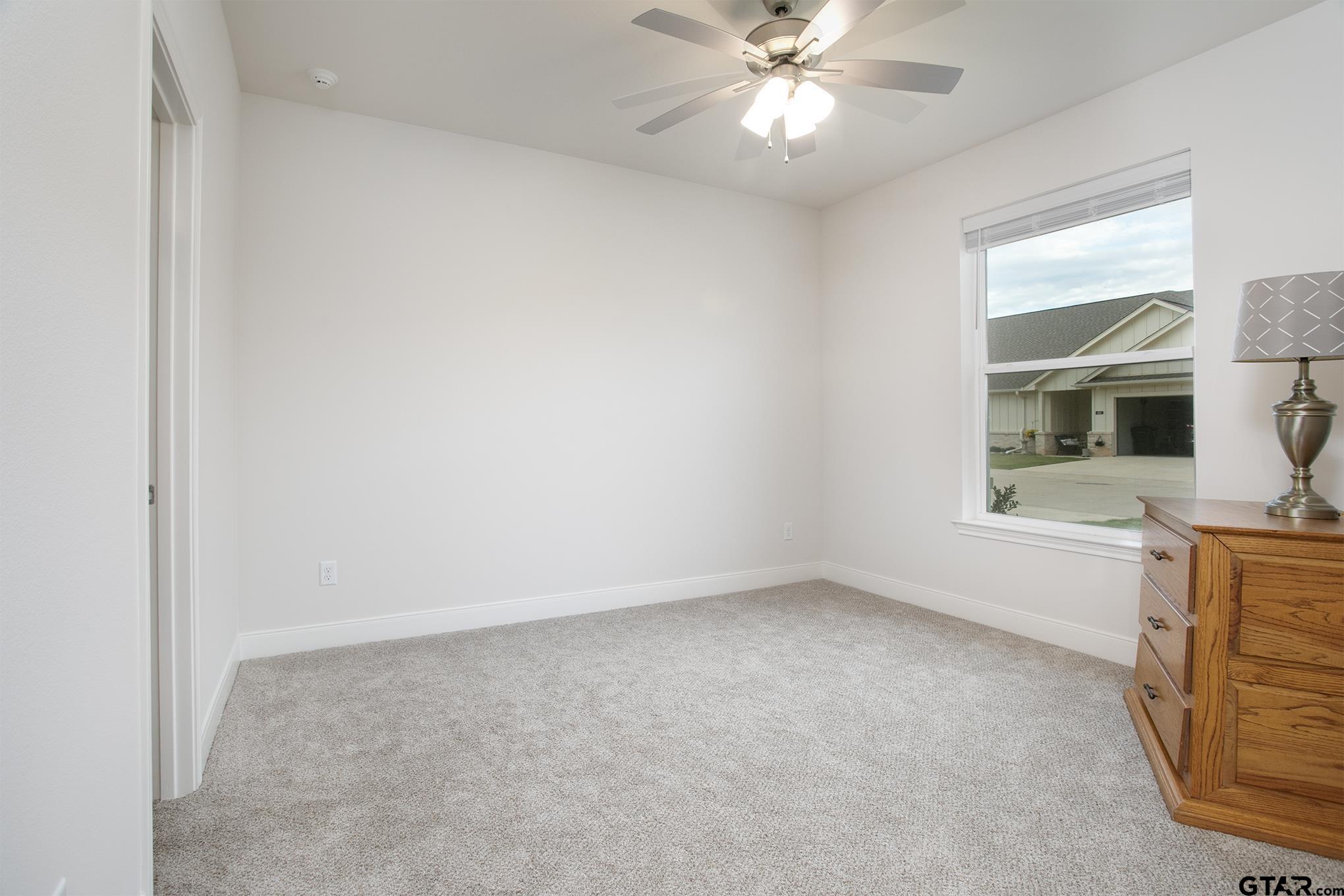 6143 Hamilton Mdws Way Tyler, TX 75703 - Photo 11 of 29 an empty room with a window and kitchen view