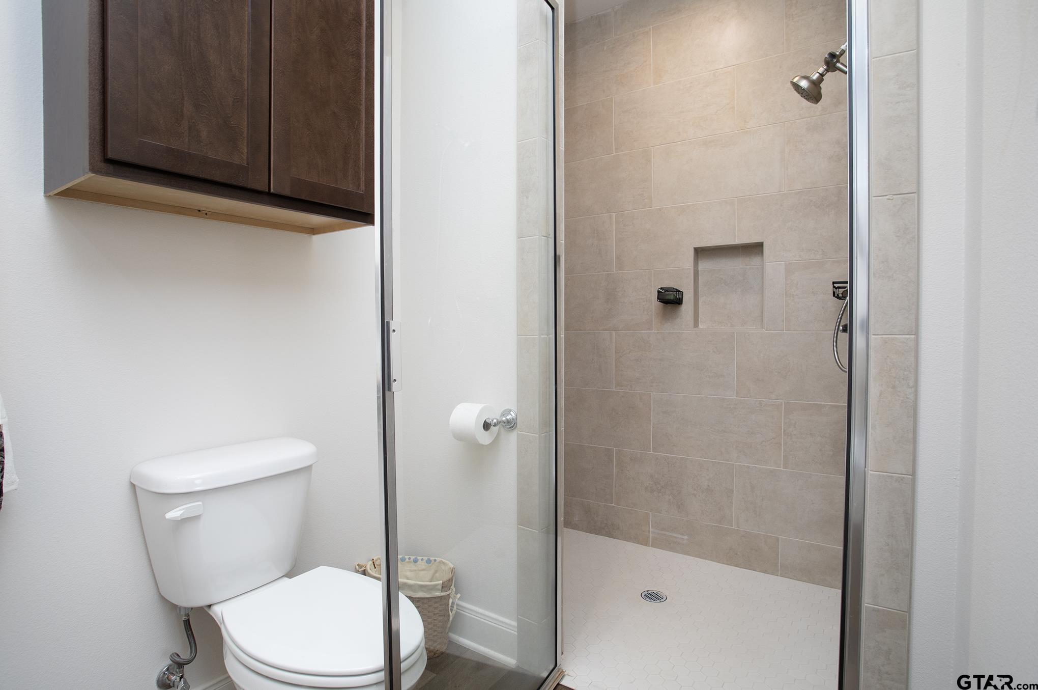 6143 Hamilton Mdws Way Tyler, TX 75703 - Photo 16 of 29 a white toilet sitting next to a bathroom sink