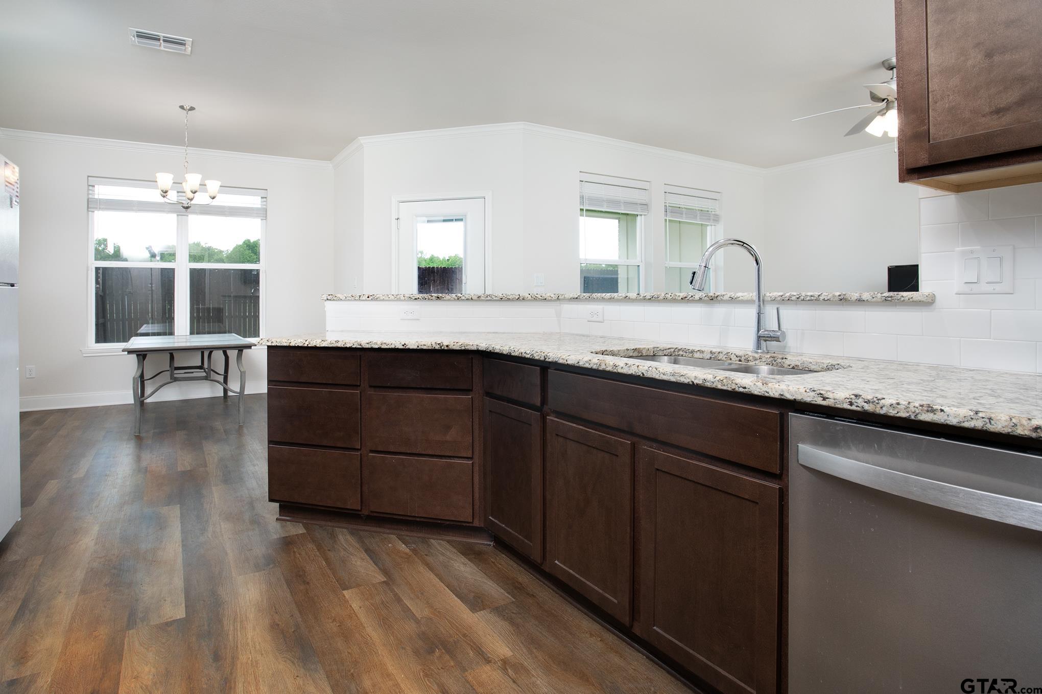 6143 Hamilton Mdws Way Tyler, TX 75703 - Photo 4 of 29 a kitchen with granite countertop a sink and cabinets