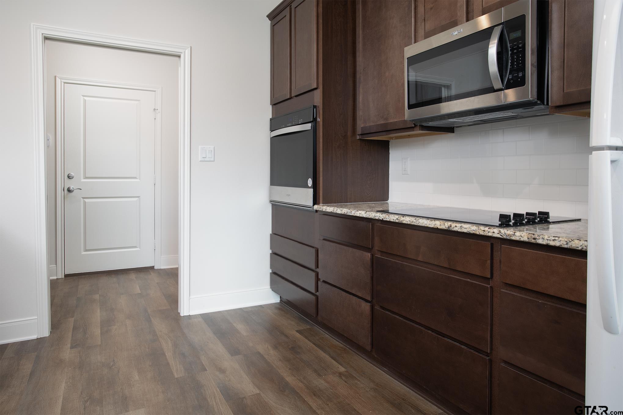 6143 Hamilton Mdws Way Tyler, TX 75703 - Photo 5 of 29 a kitchen with stainless steel appliances granite countertop a stove microwave and sink