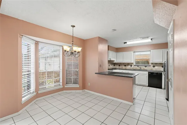 a kitchen with granite countertop a sink cabinets and stainless steel appliances