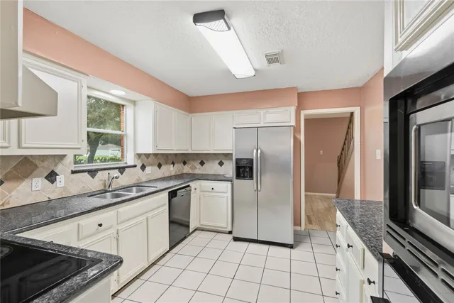 a kitchen with a sink a refrigerator and cabinets