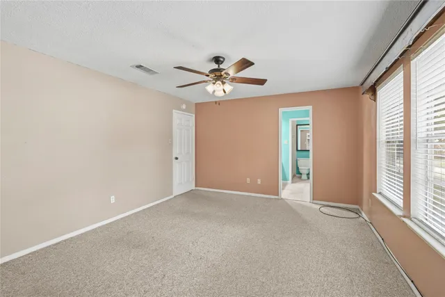 a view of a room with a ceiling fan and a window