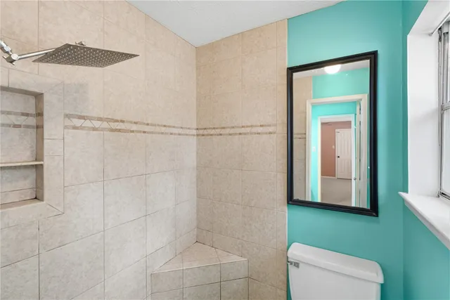 a bathroom with a toilet and a shower