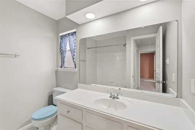 a bathroom with a sink a toilet a mirror and shower