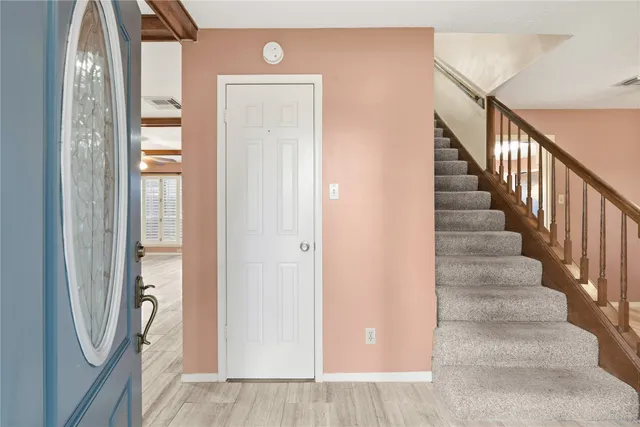 a view of a hallway with wooden floor and entryway