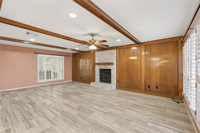 a view of an empty room with a window and fireplace