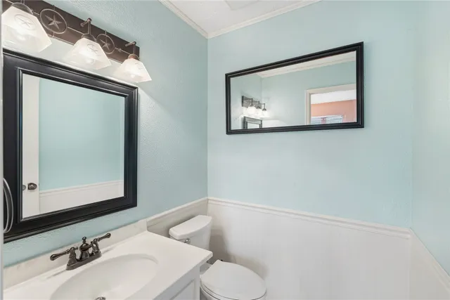 a bathroom with a toilet sink and mirror