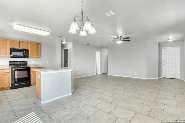 a view of kitchen with granite countertop stove top oven and cabinets