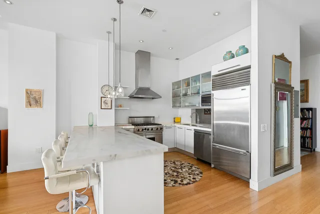 a kitchen with stainless steel appliances a refrigerator a stove a sink and a refrigerator