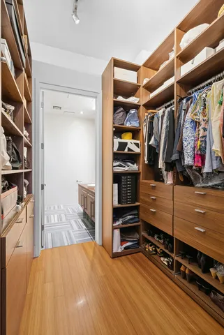 a view of walk in closet with clothes and shoes