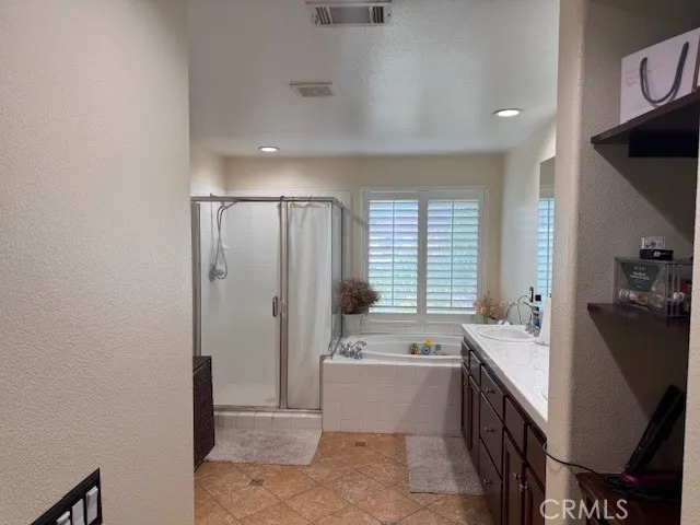 a large bathroom with a double vanity sink a large mirror and a bathtub