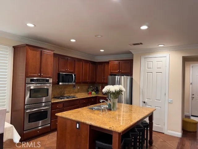 a kitchen with stainless steel appliances granite countertop a sink refrigerator and cabinets