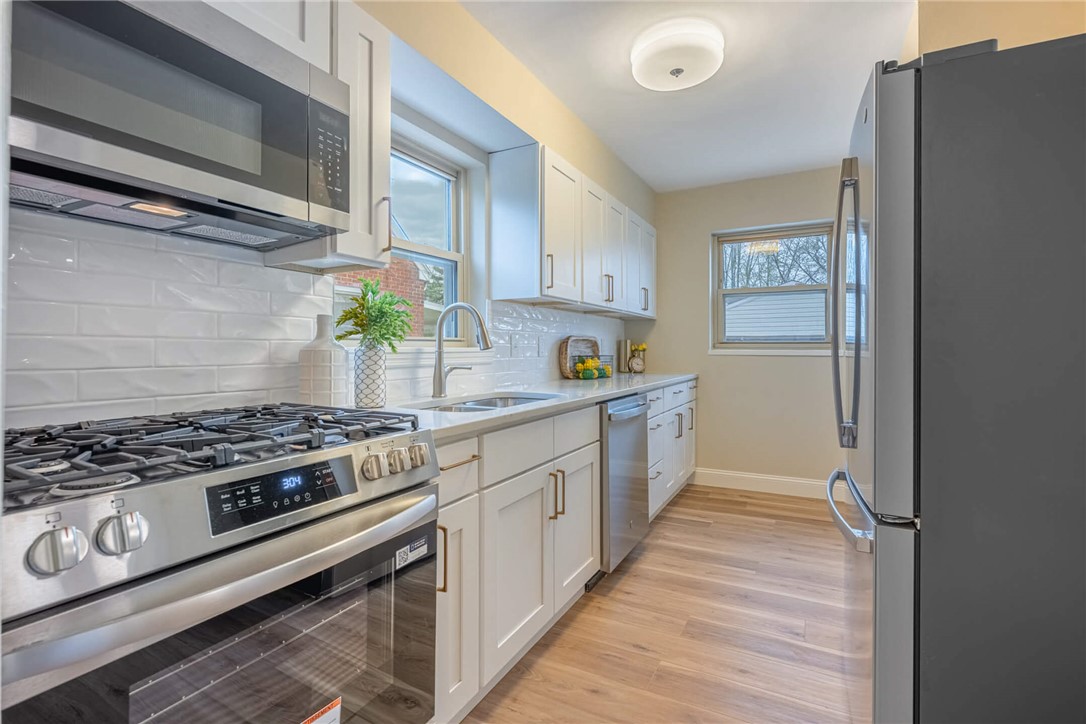 1012 Hampshire Road Dayton, OH 45419 - Photo 13 of 39 This modern kitchen features crisp white cabinetry and stainless steel appliances, creating a bright and inviting culinary space.