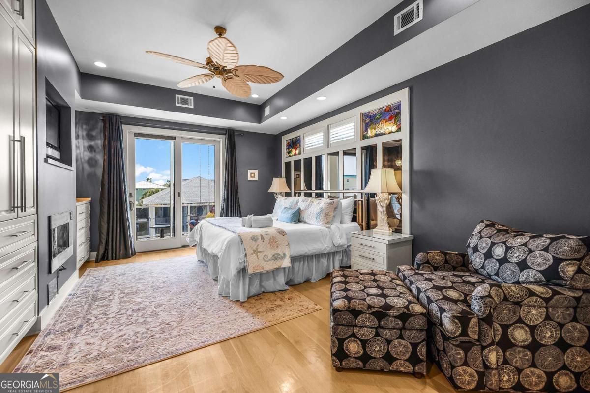 8 18th Street Tybee Island, GA 31328 - Photo 27 of 50 a spacious bedroom with a large bed and a chandelier