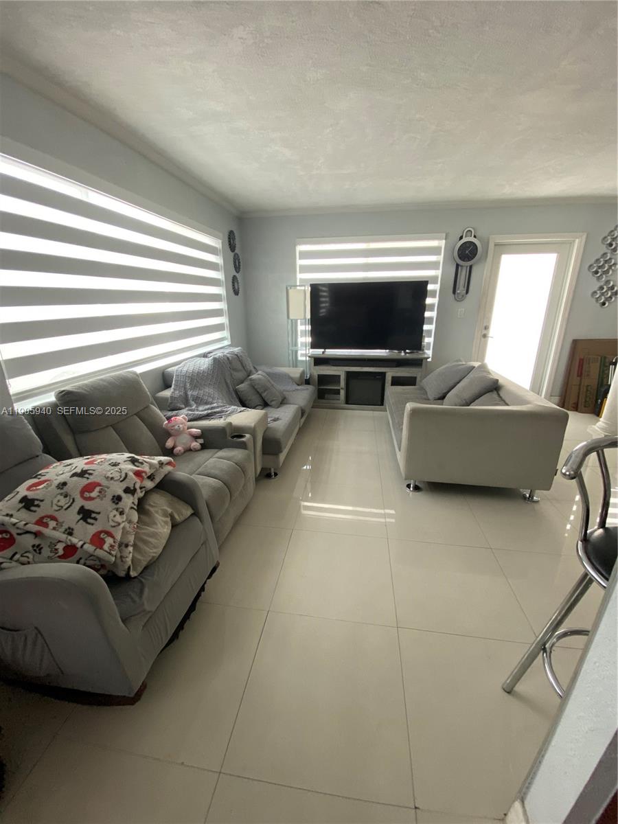 398 East 56th Street Hialeah, FL 33013 - Photo 4 of 9 a living room with furniture and a flat screen tv