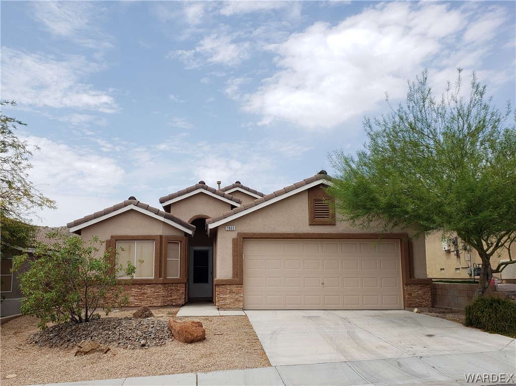 2803 Sunken Ship Street, Unit 89029 Laughlin, NV 89029 - Photo 1 of 35 a front view of a house with yard and garage