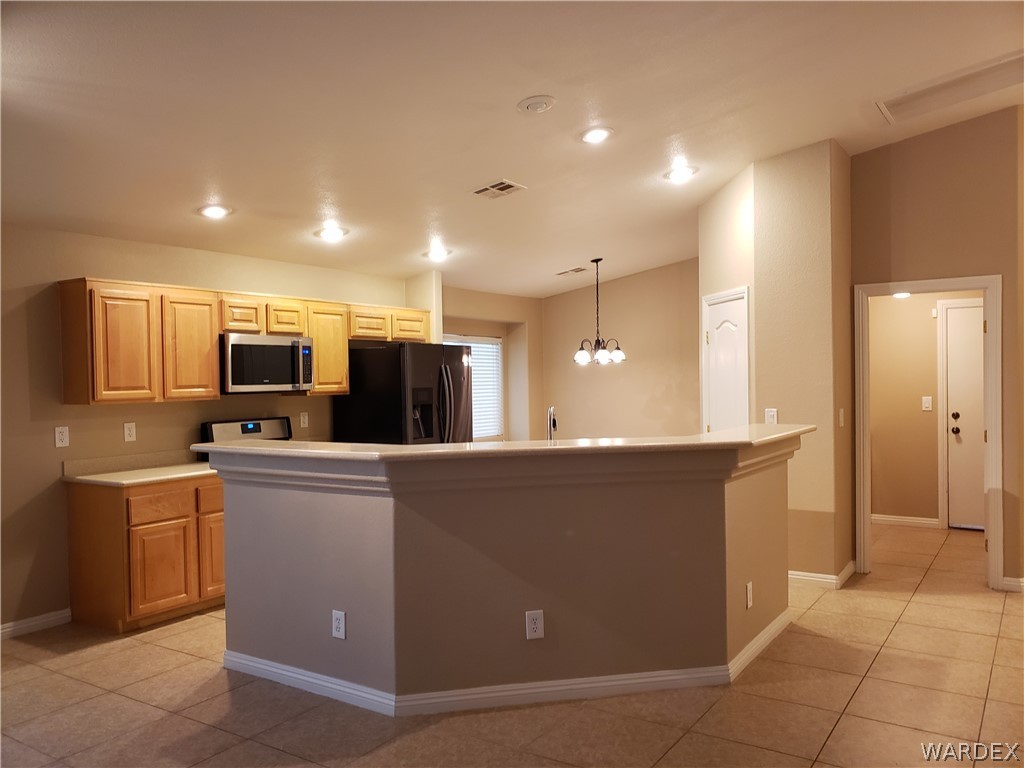 2803 Sunken Ship Street, Unit 89029 Laughlin, NV 89029 - Photo 12 of 35 a kitchen with stainless steel appliances kitchen island sink refrigerator and microwave