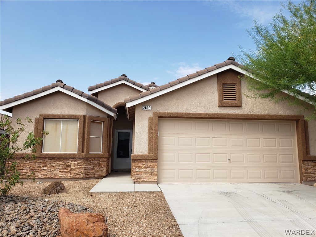 2803 Sunken Ship Street, Unit 89029 Laughlin, NV 89029 - Photo 2 of 35 a front view of a house with a yard and garage