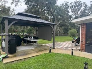 1221 Southwest Stakes Street Arcadia, FL 34266 - Photo 6 of 19 a view of a patio with table and chairs under an umbrella
