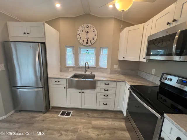 a large kitchen with a refrigerator and a sink