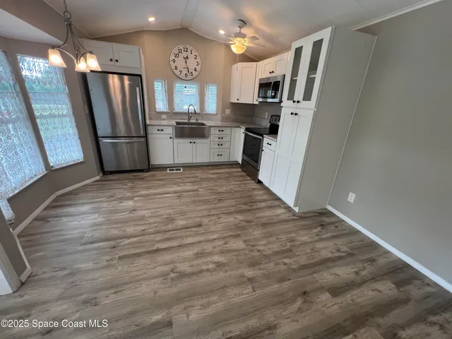 a kitchen with stainless steel appliances kitchen island granite countertop a refrigerator and a stove top oven