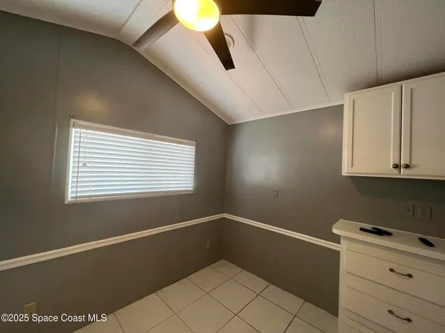 a view of a livingroom with an empty space and a ceiling fan