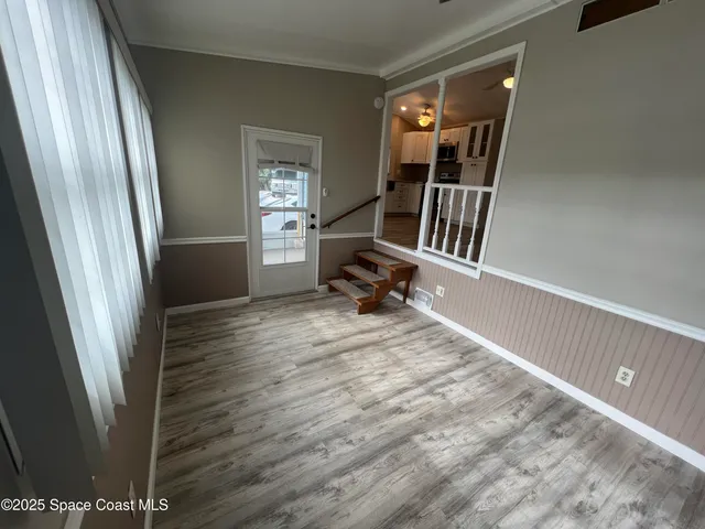 a view of a hallway with wooden floor and staircase