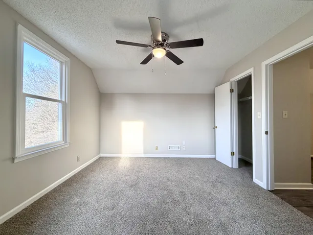 an empty room with closet and windows