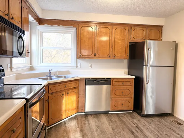 an empty room with wooden floor and a ceiling fan