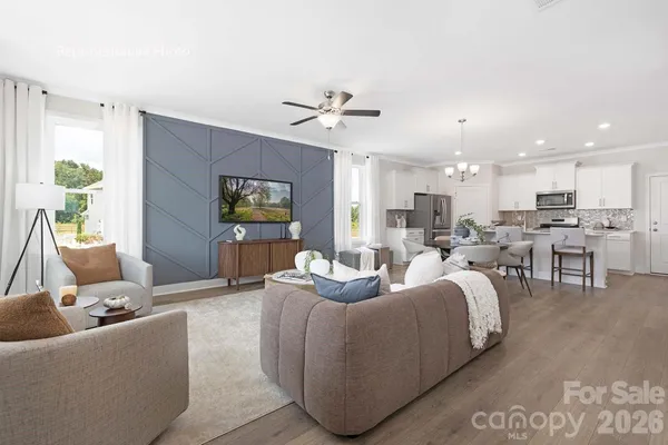 a living room with furniture kitchen view and a chandelier