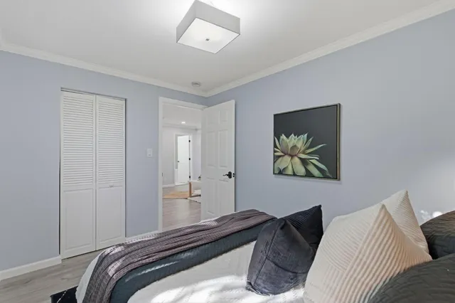 a bedroom with a bed and a painting on the wall