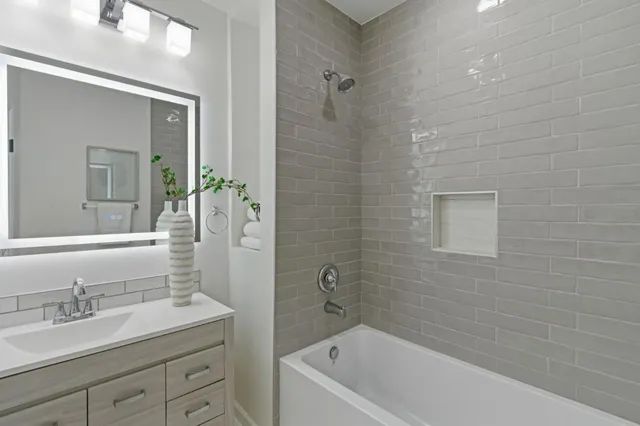a bathroom with a granite countertop sink a toilet and shower
