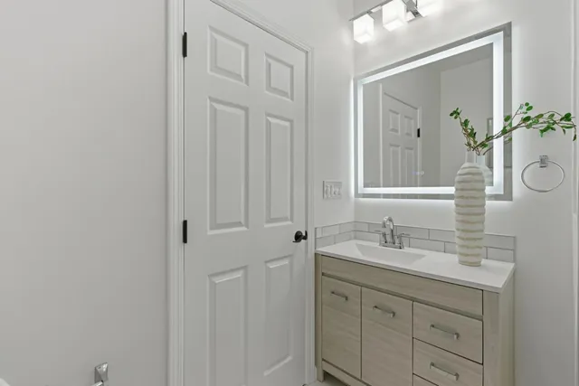 a bathroom with a sink vanity and mirror
