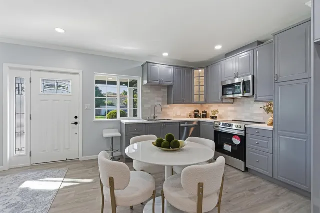 a kitchen with refrigerator cabinets dining table and chairs