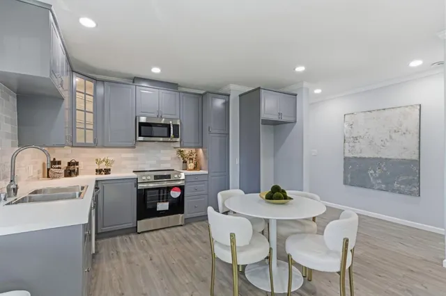 a kitchen with stainless steel appliances granite countertop a kitchen island hardwood floor sink and stove