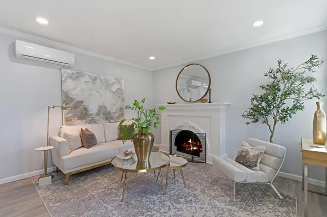 a living room with furniture a fireplace and a potted plant