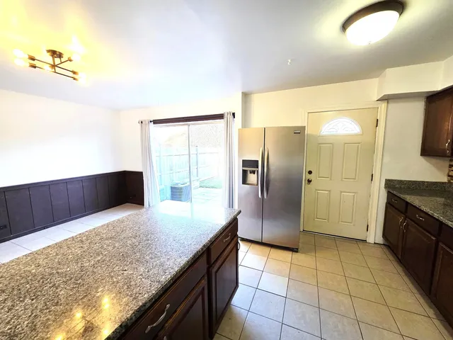 a kitchen with stainless steel appliances granite countertop a refrigerator and a sink