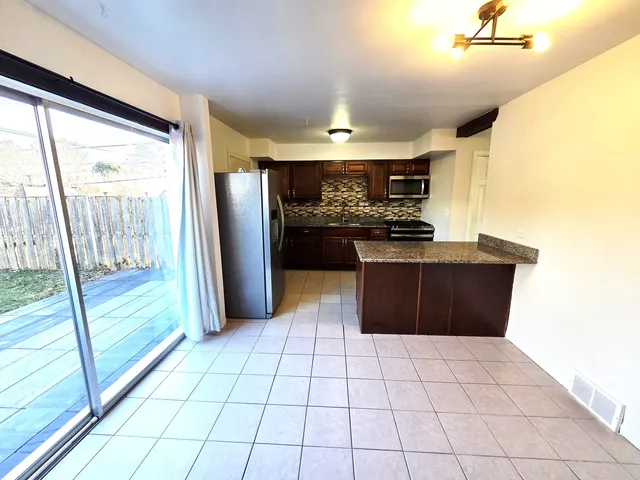 a large kitchen with a large window cabinets and stainless steel appliances