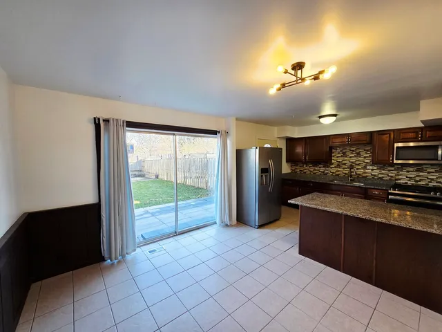 a kitchen with stainless steel appliances granite countertop a stove a sink and a refrigerator