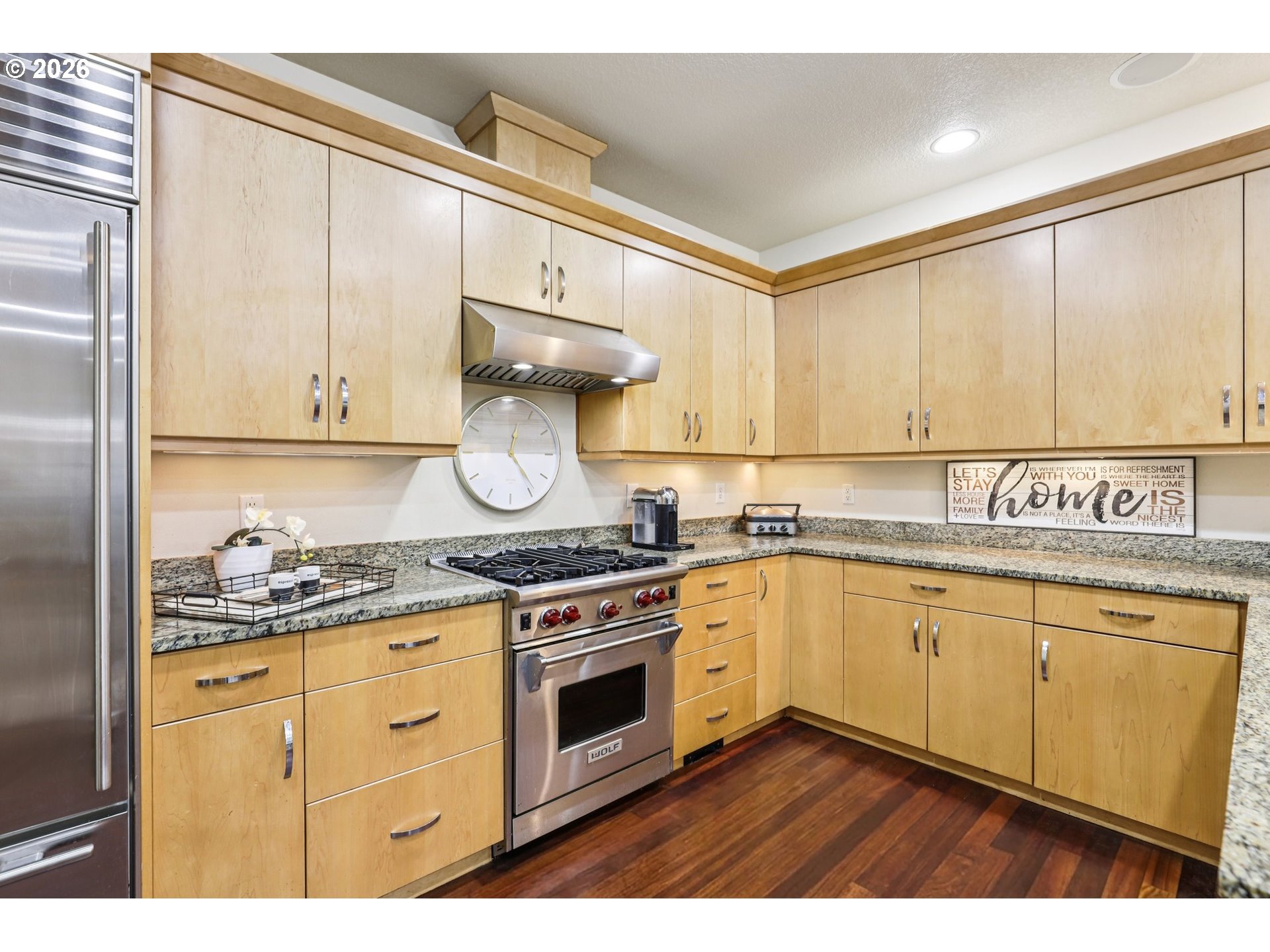 7812 Northwest Quinault Street Camas, WA 98607 - Photo 10 of 48 a kitchen with stainless steel appliances granite countertop a stove a sink and white cabinets with wooden floor
