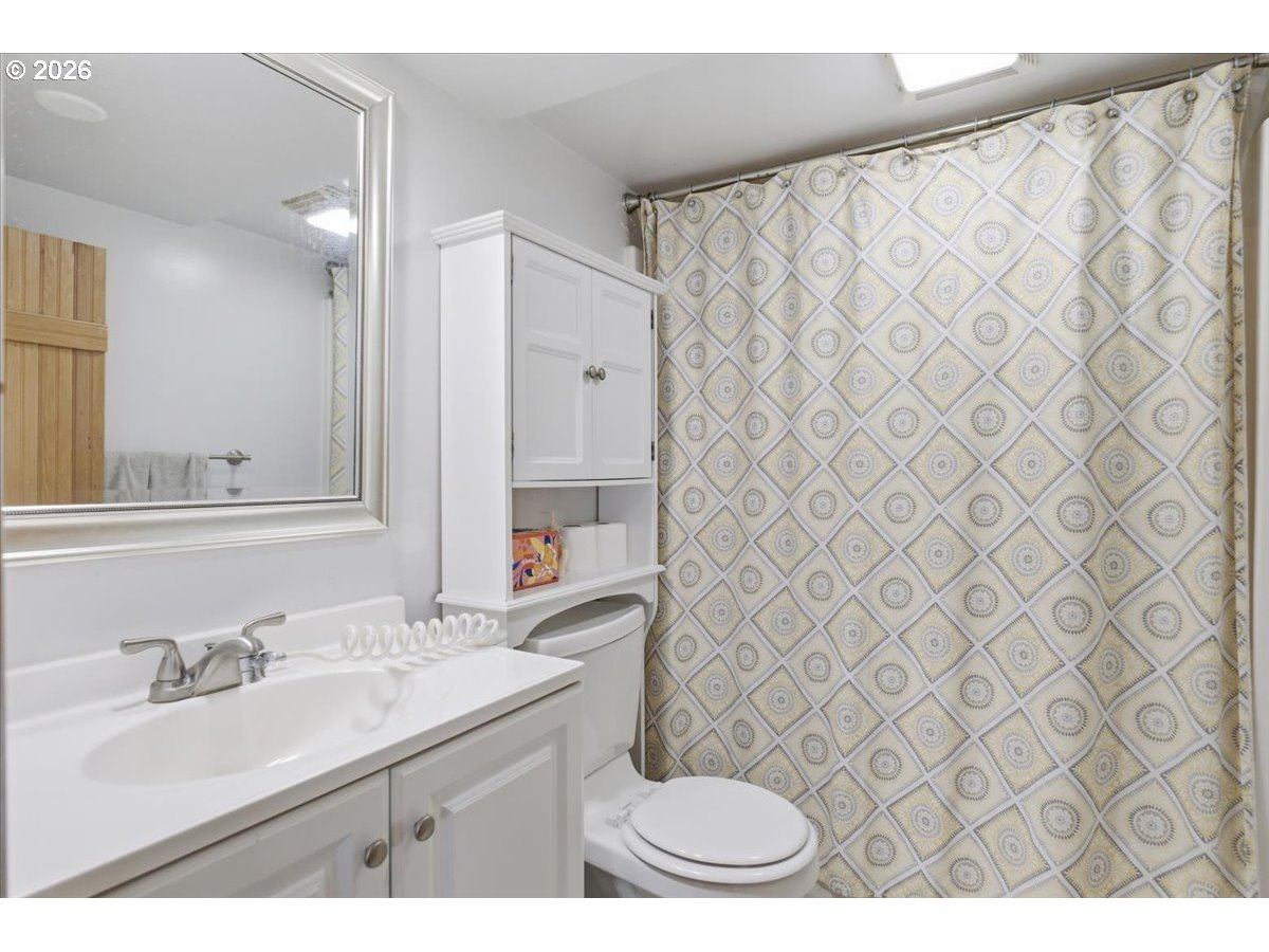 1121 Main Street Dallas, OR 97338 - Photo 39 of 48 a bathroom with a sink a toilet a mirror and shower curtain