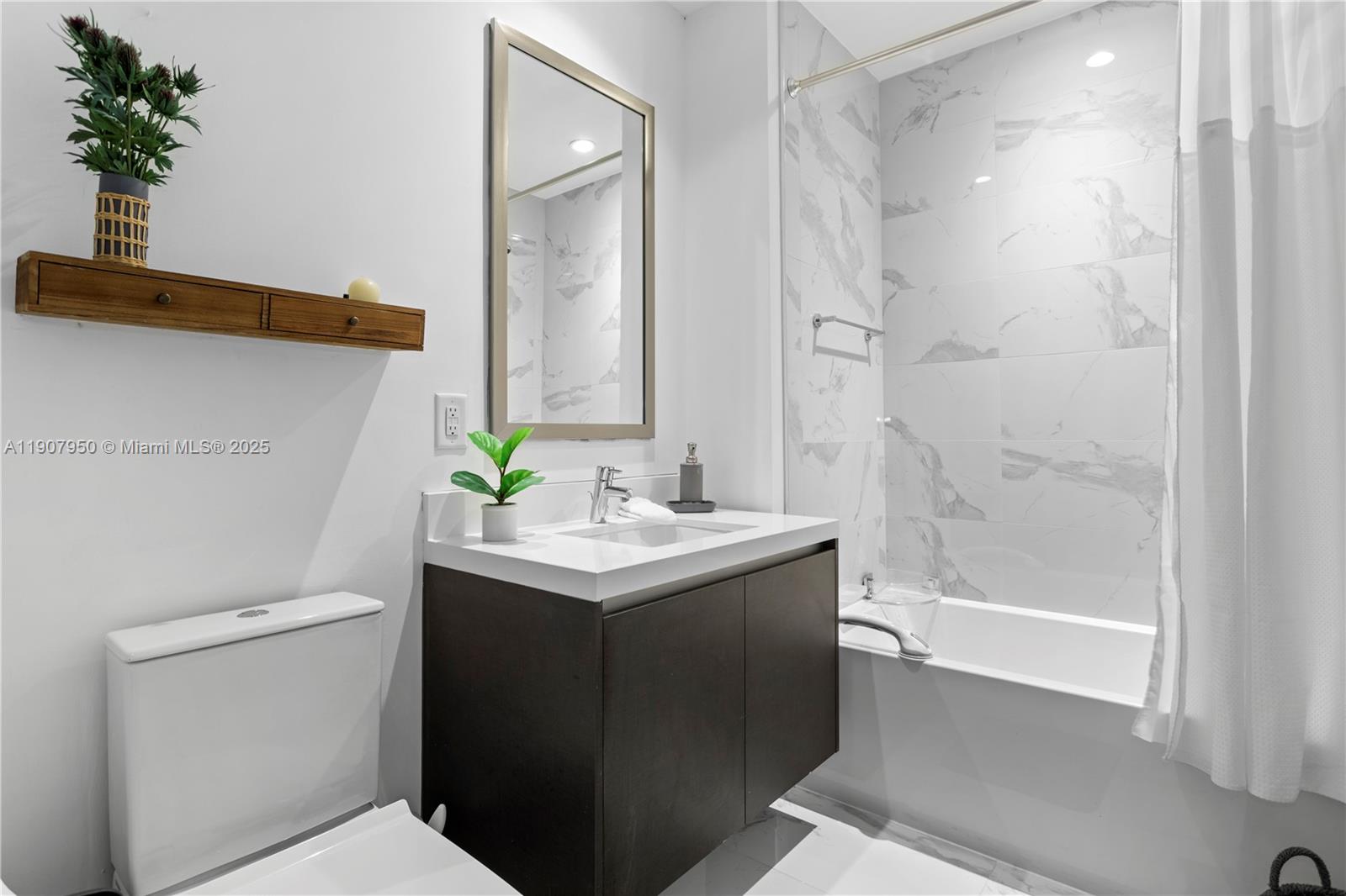 851 Northeast 1st Avenue, Unit 3907 Miami, FL 33132 - Photo 10 of 20 a bathroom with a sink a toilet and shower