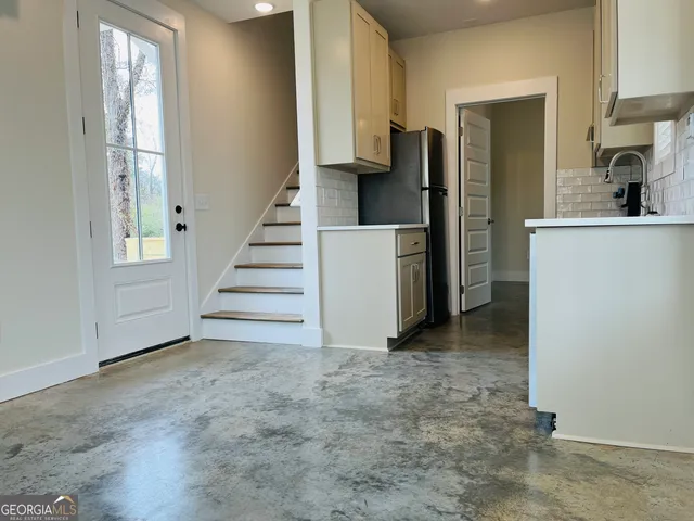 a view of a kitchen with a sink and refrigerator