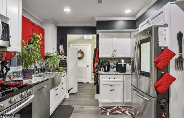 a kitchen with stainless steel appliances kitchen island granite countertop a refrigerator and a stove