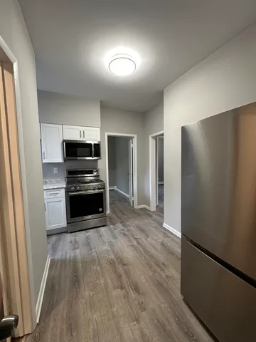 a kitchen with a refrigerator and a stove top oven