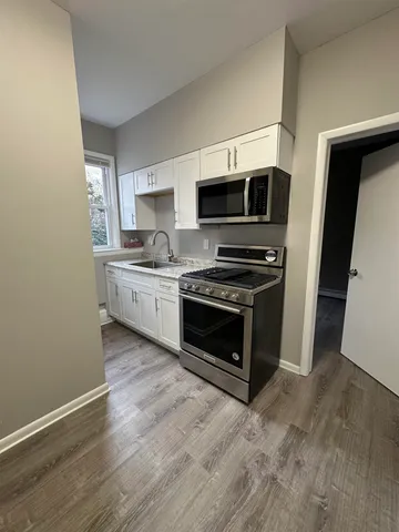 a kitchen with granite countertop a stove top oven and sink